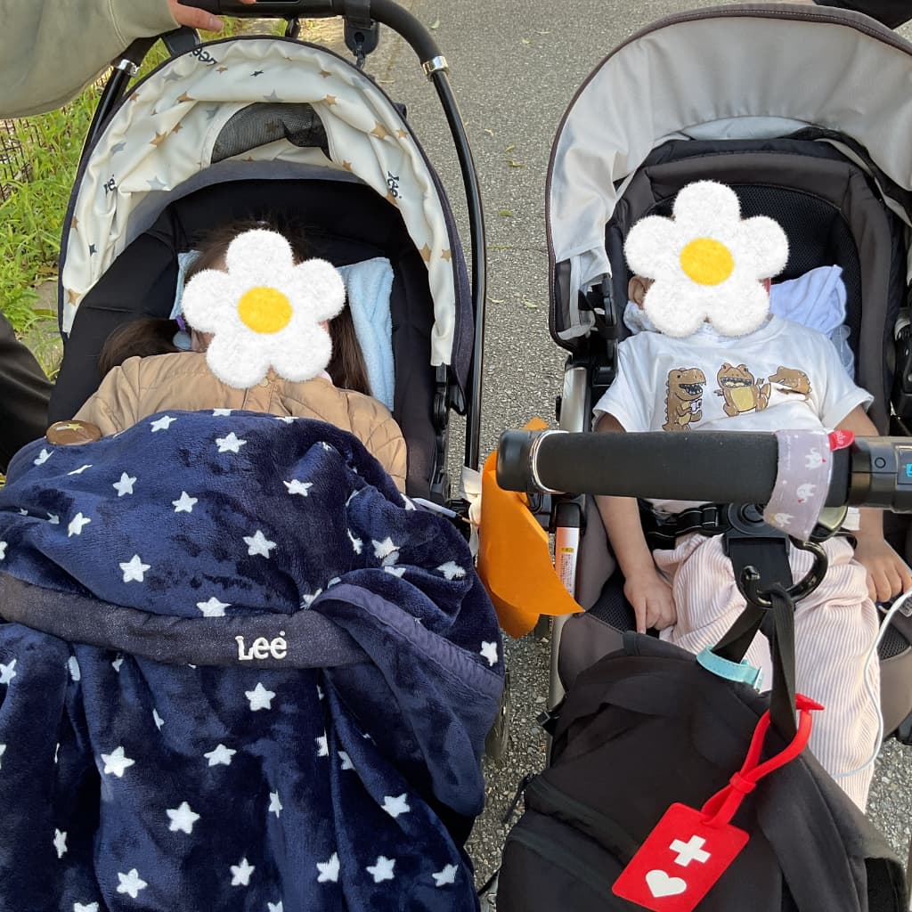 並んだベビーカーの中で、子どもたちが毛布に包まれている様子