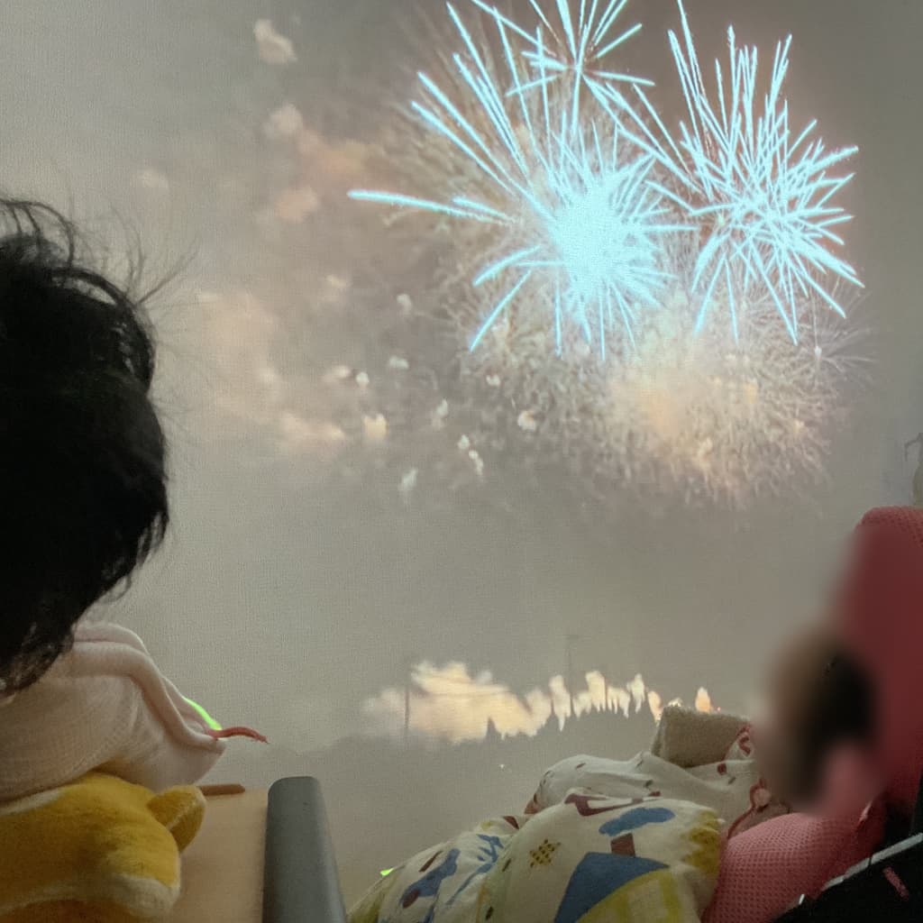 室内の壁に映し出された花火の映像を子どもたちが鑑賞している様子